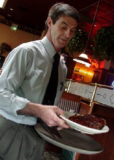 Sam serving platters of ribs.